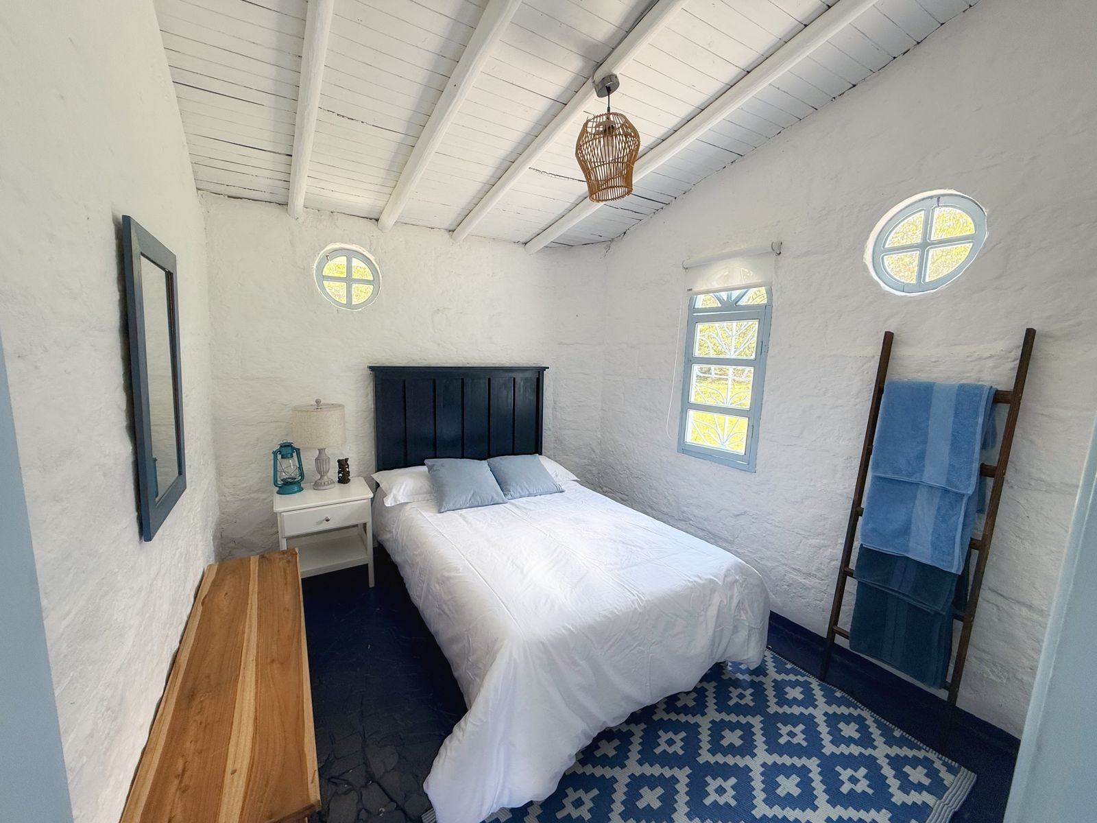 Habitación con cama doble y ventana redonda